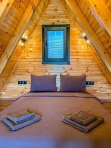a bed in a log cabin with a window at SAPANCA BUNGALOVCA in Sapanca