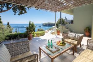 a patio with a table and chairs and a view of the ocean at Kalami Beach - Villa Almyra in Kalami