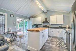 a large kitchen with white cabinets and a table at Cozy North Bend Getaway Near Dunes and Ocean! in Lakeside
