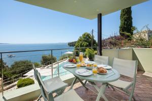 a table and chairs on a balcony with a view of the ocean at Kalami Beach - Villa Almyra in Kalami
