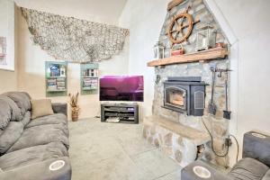 a living room with a stone fireplace and a tv at Oceanside Getaway with Beach Access and Home Gym! in Coos Bay