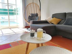 uma sala de estar com um sofá e uma mesa com duas velas em Marreiro's house Algarve - Child friendy - Private Pool em Lagos