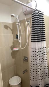 a bathroom with a shower curtain and a toilet at Grand Riviera Suites Comfy Condo near US Embassy Manila Bay Roxas Blvd Ermita Manila in Manila