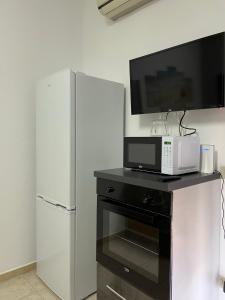 a microwave and a refrigerator with a tv on top of it at La Tartaruga apartment Giardini Naxos in Giardini Naxos