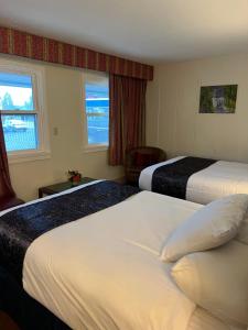Habitación de hotel con 2 camas y ventana en Itascan Motel, en Grand Rapids