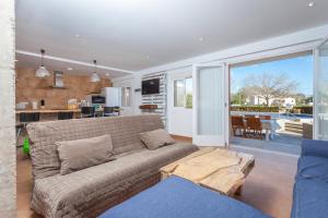 een woonkamer met een bank en een tafel bij Blick auf Atalaya in Port de Pollença