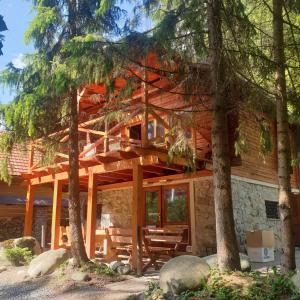a log cabin with a deck in the trees at TATRYSTAY Chalet Kristina in Belá