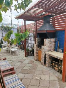a patio with an outdoor oven with a table and chairs at Tormalyn Spa in Coquimbo