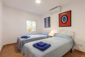 a bedroom with two beds and a window at Blick auf Atalaya in Port de Pollensa