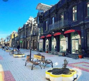 a street with benches and buildings in a city at Gyumri house in Gyumri