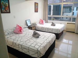 two beds with pink pillows in a room with a window at Sandz accomodation at 108 in Durban
