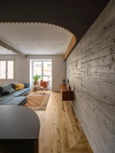 a living room with a large concrete wall at City Centre San Mamés by Next Stop Bilbao in Bilbao