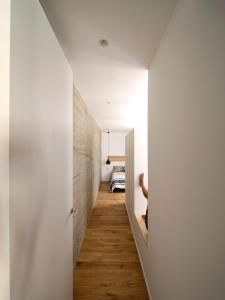 un corridoio che conduce a una camera da letto con pareti bianche e pavimenti in legno di City Centre San Mamés by Next Stop Bilbao a Bilbao