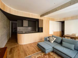 salon z niebieską kanapą i kuchnią w obiekcie City Centre San Mamés w mieście Bilbao