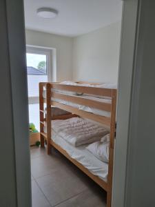 a bedroom with two bunk beds in a room at NEU!Moderne, lichtdurchflutete DHH, zentral, Garten, Wallbox, WLAN in Butjadingen