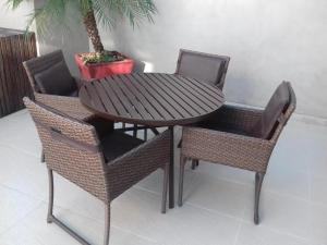 einen Holztisch, 2 Stühle und einen Tisch mit Tisch und Stühlen in der Unterkunft Flat Completo no Soho Promenade - Wi-Fi e NF in Campos dos Goytacazes