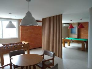 ein Esszimmer mit einer Tischtennisplatte und einer Poollinsula in der Unterkunft Flat Completo no Soho Promenade - Wi-Fi e NF in Campos dos Goytacazes