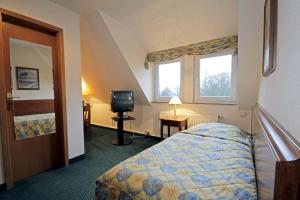 a hotel room with a bed and a television at Parkhotel Oybin in Kurort Oybin