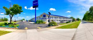 a large building on a street with a road at Travelodge by Wyndham Madison Heights MI in Madison Heights