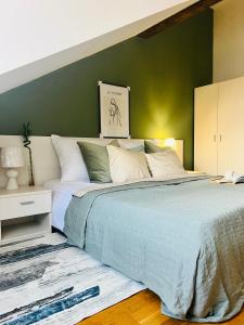 a bedroom with a large bed with a green wall at Black Pearl by Vysehrad Castle in Prague