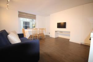a living room with a couch and a dining room at Superb flat near Victoria station in London