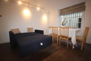 a bedroom with a bed and a table and chairs at Superb flat near Victoria station in London