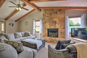 a living room with couches and a stone fireplace at Table Rock Lake Getaway with Fire Pit, Deck and Grill! in Golden