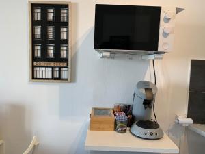 a room with a table with a blender and a flat screen tv at Escale St Charles - 150m de la Gare, vue sur Notre-Dame de la Garde in Marseille