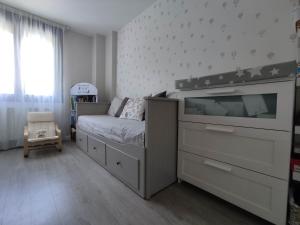 een slaapkamer met een bed en een dressoir met een tv bij Precioso apartamento con terraza, pistas de padel y piscinas in Castro-Urdiales