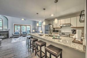 a kitchen with a counter and some bar stools at Dreamy, Family-Friendly Cloudcroft Townhome! in Cloudcroft