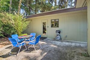 a patio with a table and chairs in front of a house at Coos Bay Cottage with Fireplace and BBQ Patio! in Coos Bay
