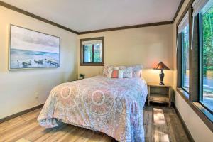a bedroom with a bed and two windows at Coos Bay Cottage with Fireplace and BBQ Patio! in Coos Bay
