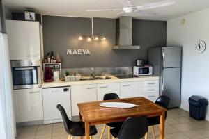 阿魯埃的住宿－NAIA LODGE，厨房配有木桌和黑色椅子