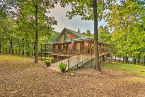 une cabane en rondins avec drapeau dans les bois dans l'établissement Lakefront Hideaway in Scranton Spacious Deck, à Scranton