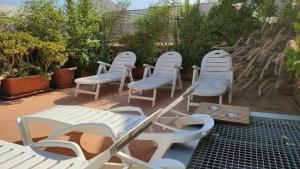un grupo de sillas y mesas blancas en un patio en Diagonal Apartments, en Barcelona