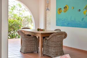 een houten tafel met rieten stoelen in een kamer bij Kas di Bientu at Windsock Beach in Kralendijk