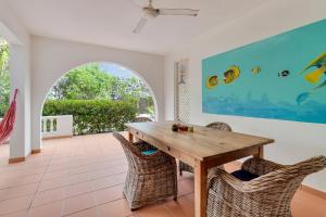 Kas di Bientu at Windsock Beach في كراليندايك: غرفة طعام مع طاولة وكراسي خشبية