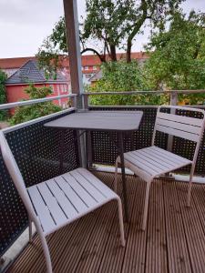 two white chairs and a table on a balcony at Appartement OTTO I - Erfurt Zentrum in Erfurt