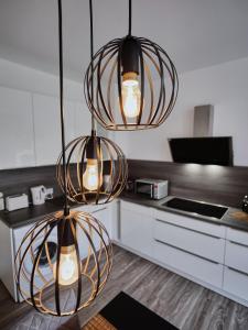 una cocina con tres luces colgando del techo en Appartement OTTO I - Erfurt Zentrum, en Erfurt