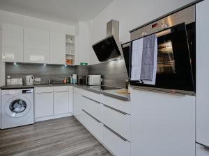 a kitchen with white cabinets and a washer and dryer at Appartement OTTO I - Erfurt Zentrum in Erfurt