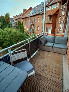 a balcony with a couch and chairs on a building at Appartement OTTO I - Erfurt Zentrum in Erfurt