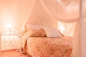 Dormitorio blanco con cama con dosel en Casa alle Monache, en Gambassi Terme