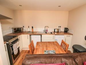 a kitchen with a wooden table and a couch at Grimes Nook in Staithes