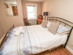a bedroom with a bed with white sheets and pillows at Grimes Nook in Staithes