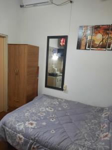 um quarto com uma cama e um espelho em Complejo las Palmeras em Godoy Cruz