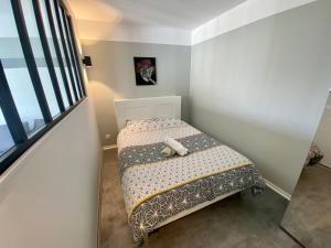 mała sypialnia z łóżkiem i oknem w obiekcie Le cœur de Rive gauche - Superbe T3 - parking - 082 w Rouen