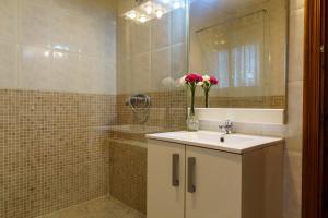 a bathroom with a sink with a vase of flowers on it at Casa Rural Campoamor in Carboneras de Guadazaón