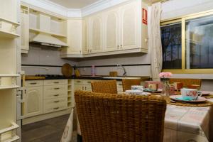 a kitchen with white cabinets and a table with chairs at Casa Rural Campoamor in Carboneras de Guadazaón +27 photos