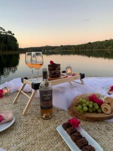 a table with a glass of wine and some food at Pousada Bellatrix Ecolodge in Praia do Forte