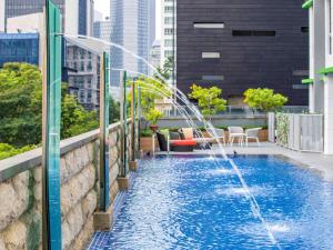 a swimming pool with a fountain on a rooftop at ibis Styles Singapore Albert in Singapore